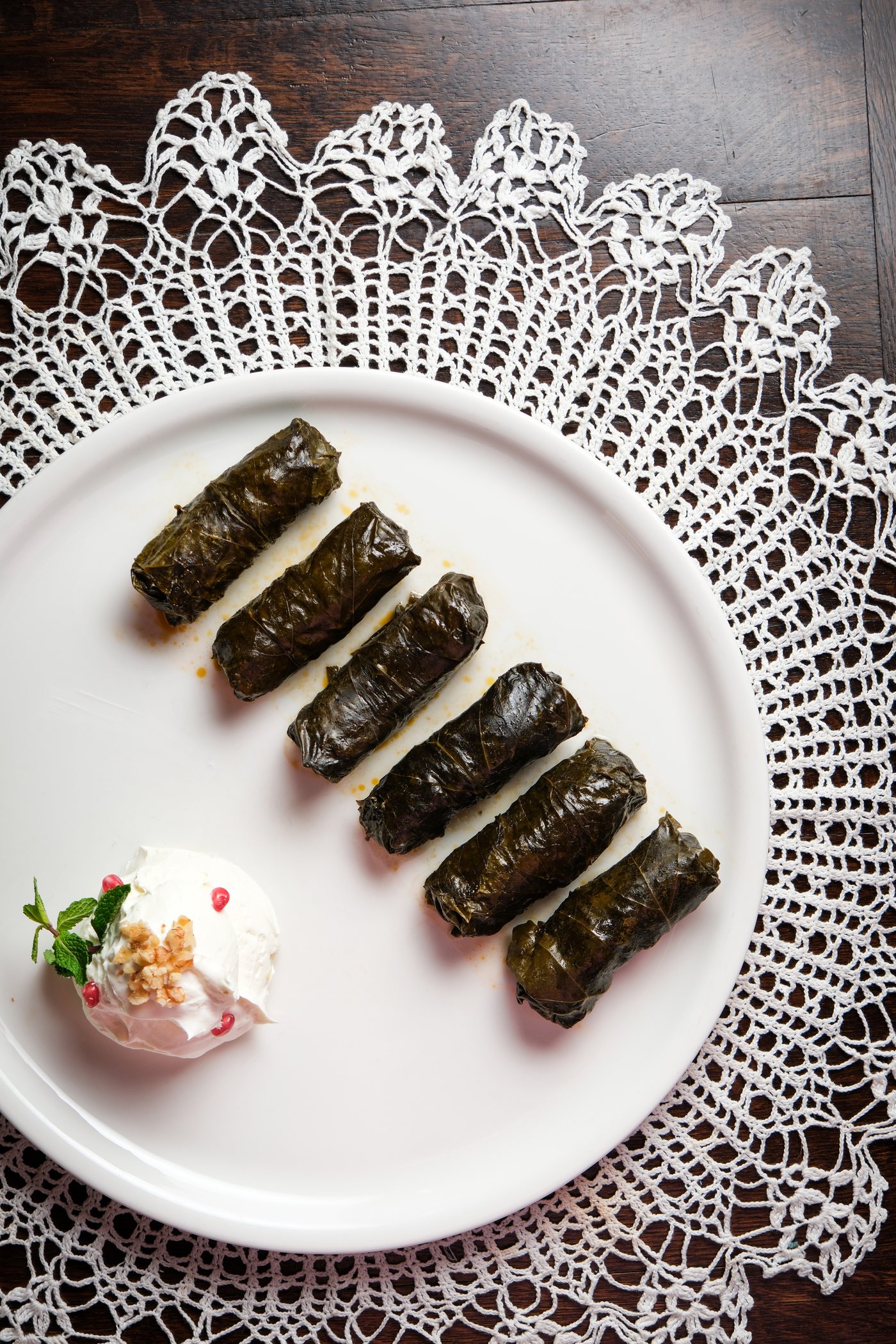 Dolmama signature grape leaf dolma arranged on lace