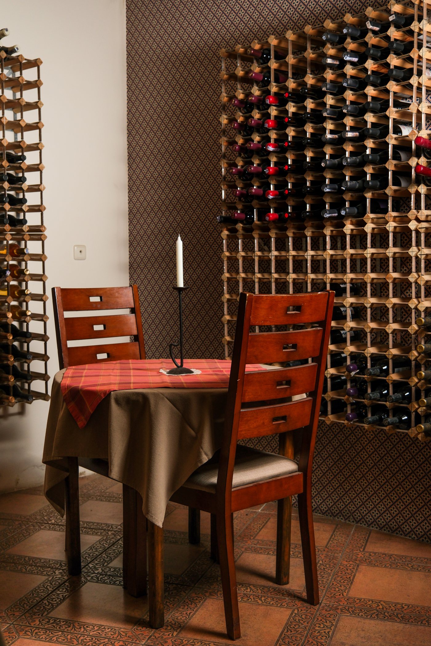 Private wine-room table with bottle wall and candlelight